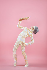Studio image of a young teen girl bandaged, on pink background. Bloody Halloween theme: the crazy maniak studio background
