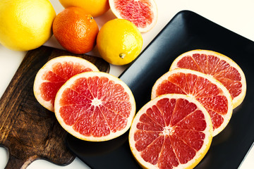 Fototapeta na wymiar Citrus fruits - grapefruits, lemons, mandarins, oranges - on table. Closeup. Selective focus.