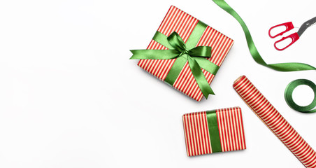 Gift boxes, packing paper, scissors, ribbon on white background. Festive background,...