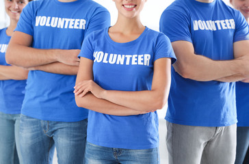 Team of young volunteers on light background. Collecting donations