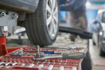 Mechanic tools lie next to the car's wheel on repair