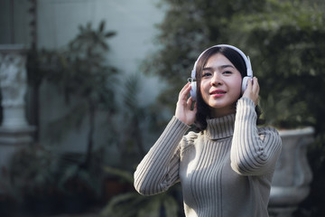 Happy Asian girls are listening to music in the park.