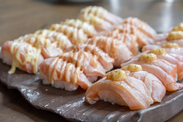 Set of Salmon aburi sushi with sauce on plate