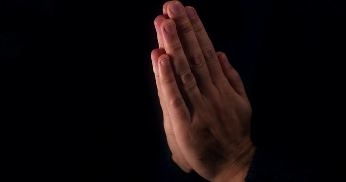 Male praying with hands clasped 
