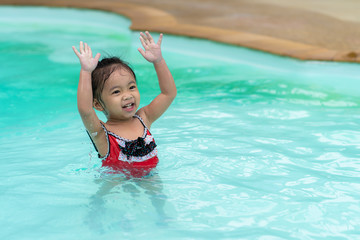 Happy baby Asian girl in swimming pool