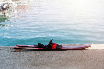 A pair of water skis stands on the beach on a Sunny day