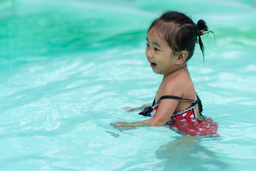 Fototapeta na wymiar Happy baby Asian girl in swimming pool