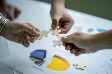 Human hand are connecting jigsaw puzzle.Business and partnership teamwork concept in selective focus