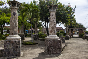 Fototapeta na wymiar Ancient Stone Columns Lining the Walkway in the Parque Xalteva Park in Downtown Granada, Nicaragua