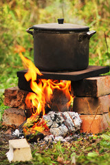 Soup with potatoes in a saucepan over a fire