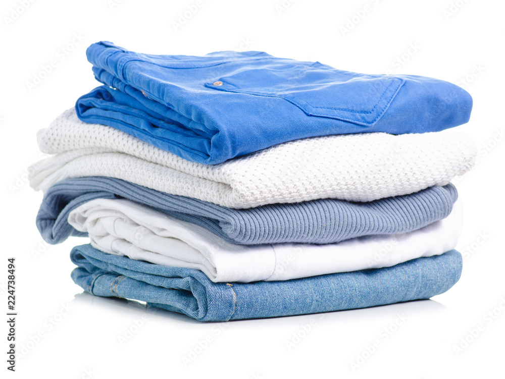 Wall mural stack of clothing jeans sweaters on a white background isolation