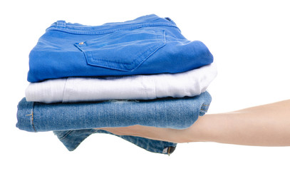 A stack of jeans clothes in hand on a white background isolation