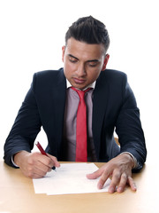 man wearing suit and tie signing contract 