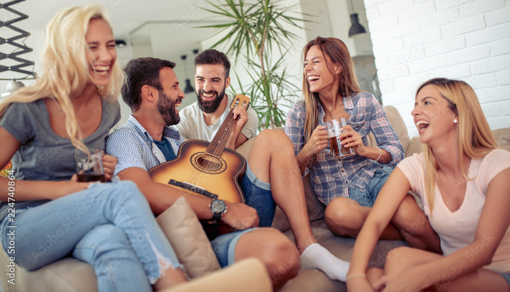 Poster happy friends playing guitar at home