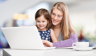 Happy mother with dauther using laptop at
