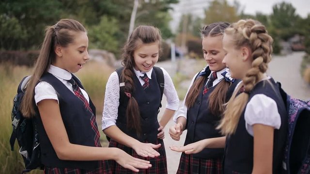 Young students playing Rock Paper Scissors. Cute schoolgirls student couple in school uniform are having fun playing