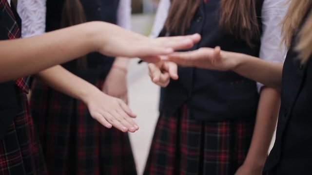 Young students playing Rock Paper Scissors. Cute schoolgirls student couple in school uniform are having fun playing