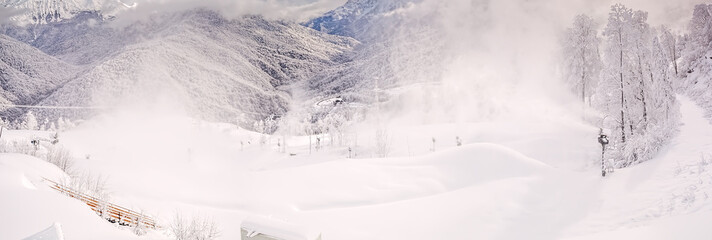 Panorama of the winter forest in the fog on the backdrop of the Caucasus mountains. Rosa Khutor.