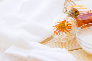 Spa and wellness setting with oil and yellow flower