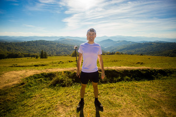 man hiker relaxing on top of hill and admiring beautiful mountain valley view in summer day
