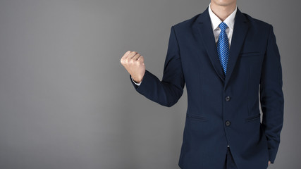 Close up of Business man in blue suit is successful  in grey background