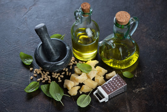 Fresh green basil, parmesan cheese, pine nuts, extra virgin olive oil and marble pouder for making pesto sauce, studio shot