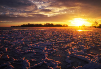 Fototapeta na wymiar Beautiful winter landscape with sunset sky and frozen lake. Composition of nature.