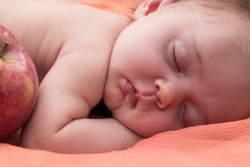 a newborn sleeps on a coverlet