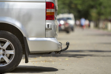 Close-up side view detail of silver passenger medium size luxury minibus van with tow-bar parked on...