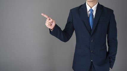 close up of business man in blue suit is pointing something on gray background