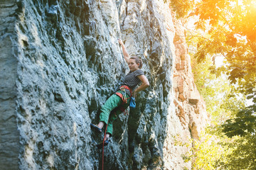 young woman rock climber climbing on the cliff