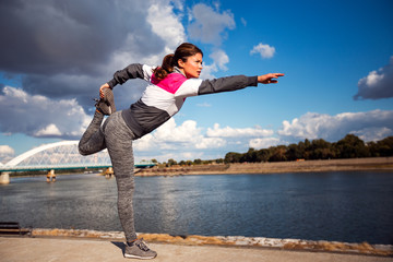 Fitness woman doing stretching exercise outdoor in urban area