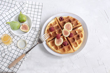 Belgian waffles Slow food breakfast concept figs raspberries honey Espresso coffee white wooden background Flat lay Copy space Horizontal