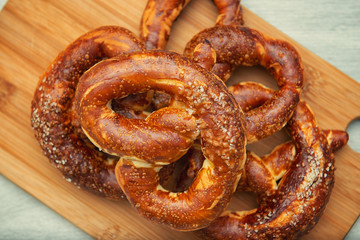 Freshly baked homemade soft pretzel with salt on wooden cutting board