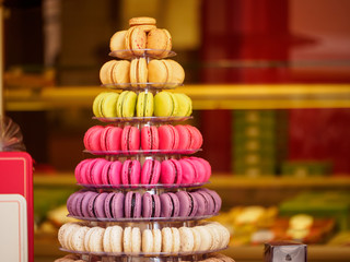 Closeup detail of multiple colorful macarons arranged on a tower at a French sweets and confectionery store. Shallow focus. Riquewihr, France. Travel and cuisine.