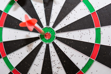 Red dart arrows hitting in the center of dartboard , Shot red dart arrow on center of dartboard