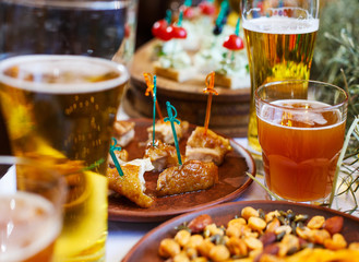 Delicious snacks for beer. Clay plate between cups of beer.