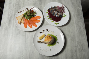 assorted fish dishes of mackerel, salmon, and trout