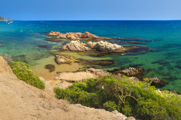 Amazing view on Platja de Santa Cristina in Lloret de Mar, Costa Brava, Spain. Rocks in turquoise water on summer sandy beach in mediterranean. Paradise lagoon in spanish resort
