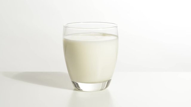 Vaso de leche en la mesa blanca