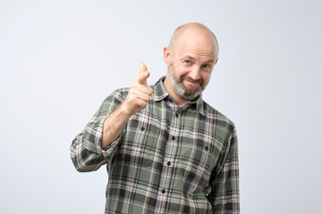 Portrait of a smiling satisfied man pointing at you isolated on a gray background like saying You are good at this.