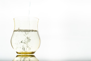 Close up of a fresh drink of water from a bottle in the studio on a white background