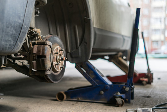 Closeup detail of the wheel assembly on a modern automobile. The rim is removed showing the front rotor and caliper.