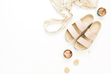 Woman gold styled fashion composition with slippers, string bag, earring and rings on white...