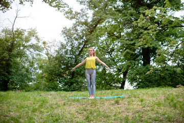 Beautiful woman practising yoga in the park