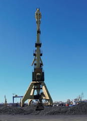 Cranes and charcoal in port with blue sky background