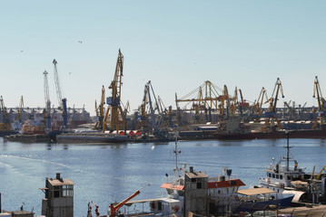 Cranes on the quay in the port and ships
