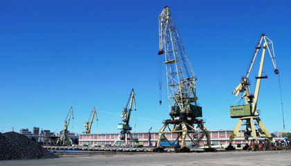 Fototapeta na wymiar Cranes on the keys in the port with blue sky