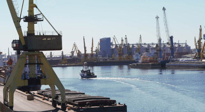 Cranes on the quay in the port and ships