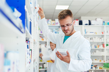 Colleagues pharmacists and chemists working at pharmacy drugstore 